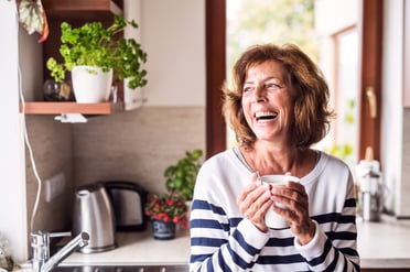 woman smiling with a cup of coffee