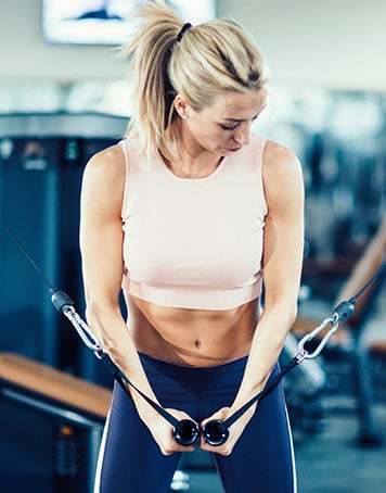 FemaleTrainerFlexingOnAArmWorkoutMachine_03