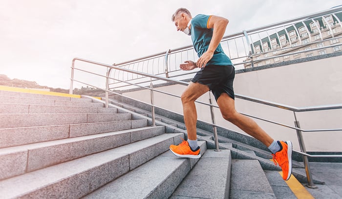 fit middle aged man running up stairs