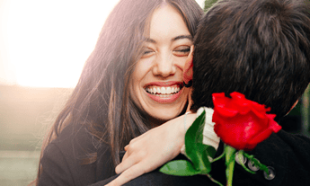 Happy-Woman-hugging-boyfriend-with rose