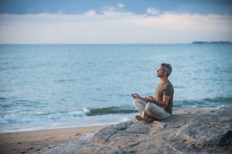 gray-hair-man-yoga-meditation-beach-stress-relief